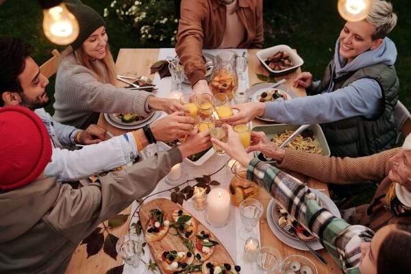 A group of friends dines together in the back area of a comfortable restaurant.