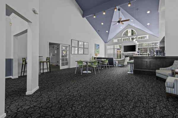 Modern lounge area with high ceilings, stylish furniture, and large windows, perfect for relaxation and socializing.