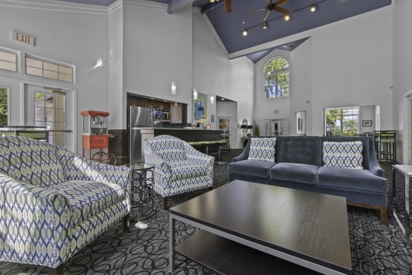Modern lounge with vibrant seating, high ceilings, and a cozy atmosphere, ideal for relaxation or social gatherings.