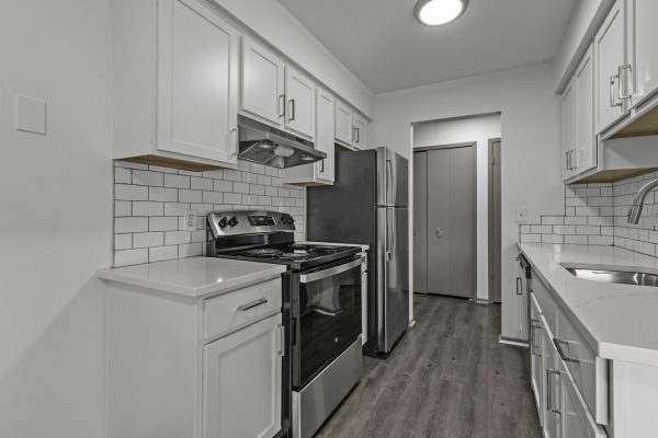 Modern kitchen with stainless steel appliances, white cabinets, and subway tile backsplash.