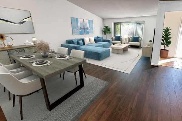 Modern open-plan living and dining area with blue sofa, wooden table, and contemporary decor.