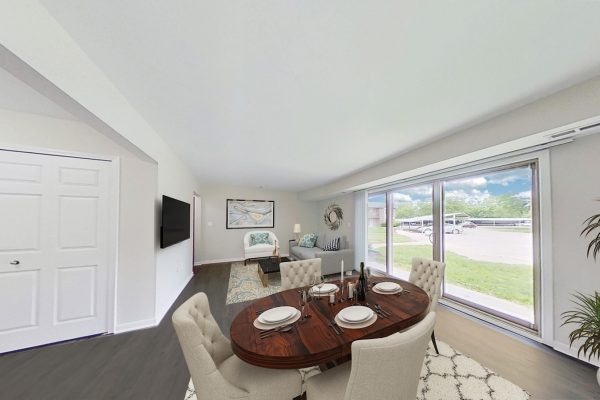 Modern dining and living room with large windows, stylish furniture, and elegant decor.