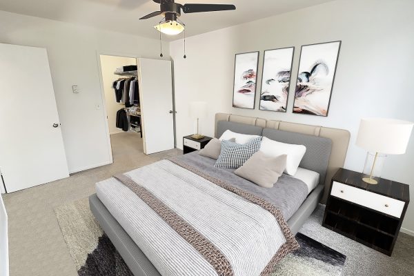 Modern bedroom with a stylish design, featuring a plush bed, abstract art, and walk-in closet for an elegant feel.