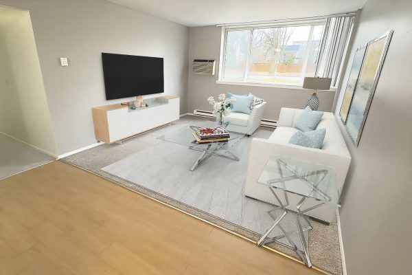 Modern living room with white sofa, glass coffee table, large TV, and window view. Elegant, minimalist decor.