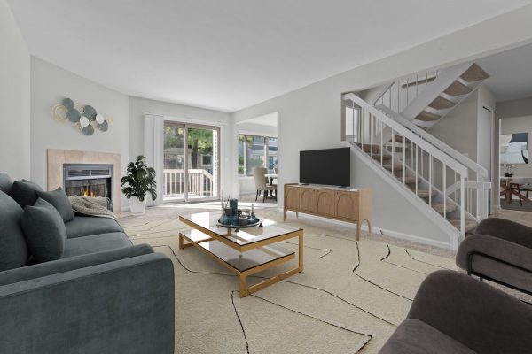 Modern living room with cozy fireplace, stylish sofa, TV under stairs, and balcony view. Cozy and elegant interior.